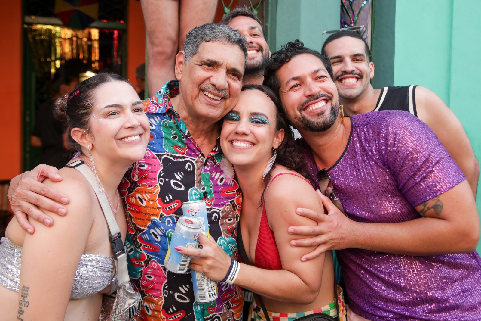 João Paulo posa sorrindo com um grupo de jovens foliões na rua